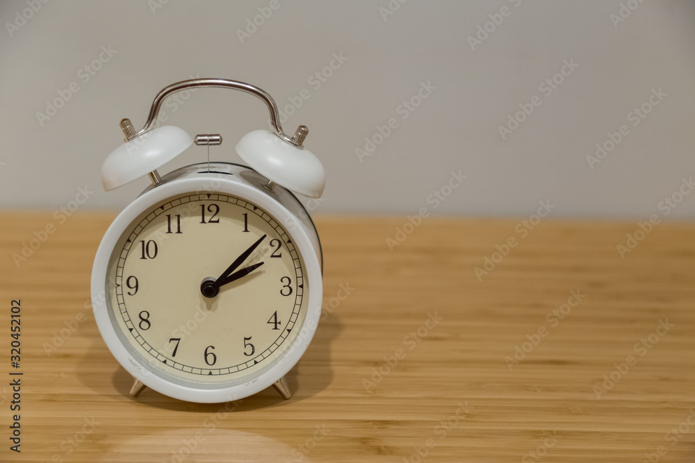 Alarm clock on the wood table beside the bed Alarm clock on the wood table beside the bed