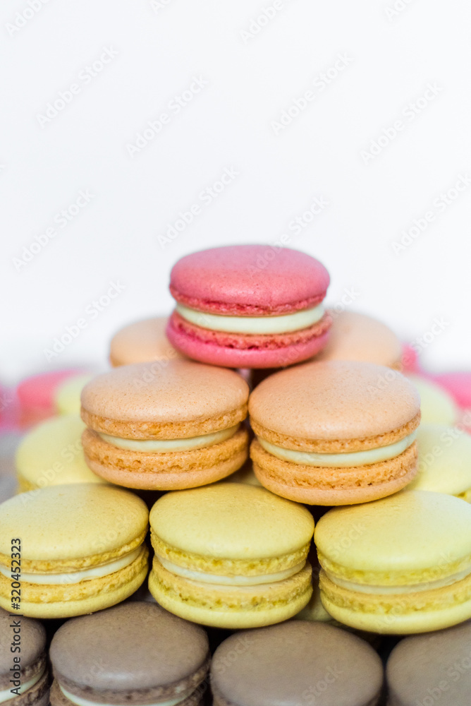 Close up of tray with lot delicious diversity pastry cakes tartlets and macaroon in a row. Fresh, multicoloured, colourful, green, yellow, white and pink sweet berry desserts, beautifully decorated Close up of tray with lot delicious diversity pastry cakes tartlets and macaroon in a row. Fresh, multicoloured, colourful, green, yellow, white and pink sweet berry desserts, beautifully decorated