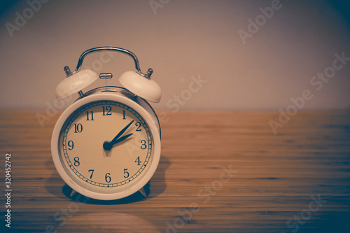 Alarm clock on the wood table beside the bed