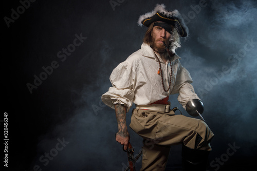 Portrait of pirate filibuster sea robber in suit with guns. Concept photo