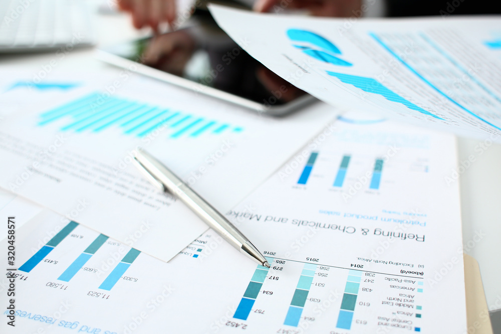 Financial statistics documents ball pen infographics at office table closeup. Internal Revenue Service inspector sum check investigation exchange market earnings savings loan and credit concept Financial statistics documents ball pen infographics at office table closeup. Internal Revenue Service inspector sum check investigation exchange market earnings savings loan and credit concept
