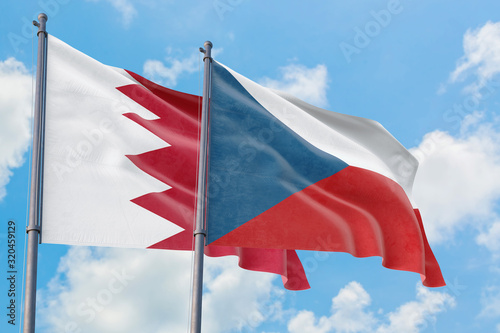 Czech Republic and Bahrain flags waving in the wind against white cloudy blue sky together. Diplomacy concept  international relations.