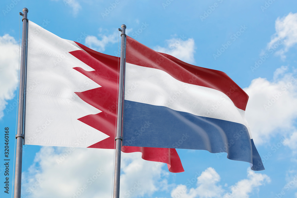 Netherlands and Bahrain flags waving in the wind against white cloudy blue sky together. Diplomacy concept, international relations. Netherlands and Bahrain flags waving in the wind against white cloudy blue sky together. Diplomacy concept, international relations.