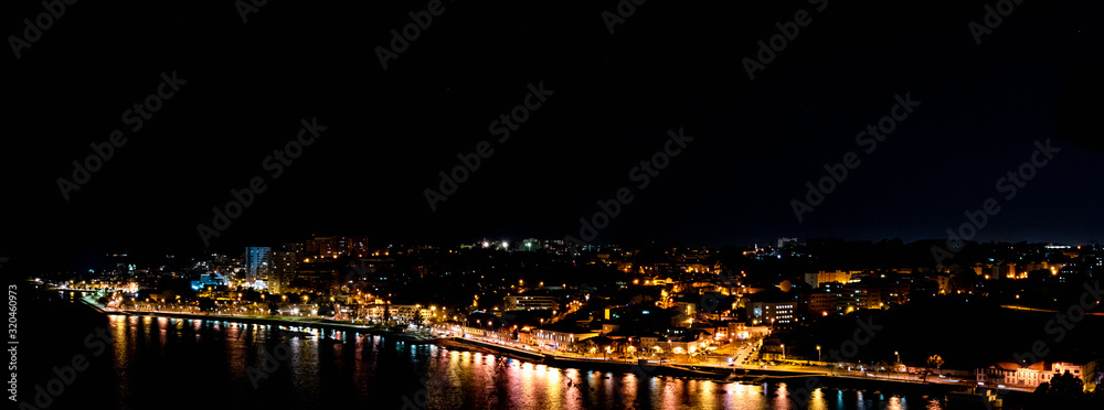 Panorama ofPorto city at night, reflection of shadows in water