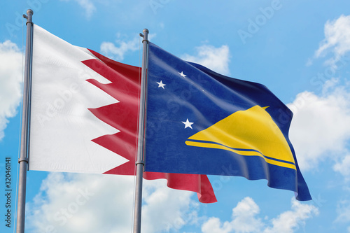 Tokelau and Bahrain flags waving in the wind against white cloudy blue sky together. Diplomacy concept, international relations.