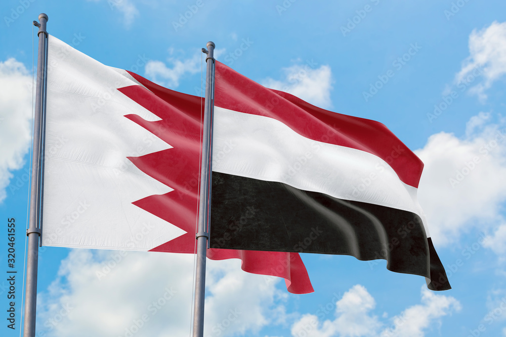 Yemen and Bahrain flags waving in the wind against white cloudy blue sky together. Diplomacy concept, international relations.