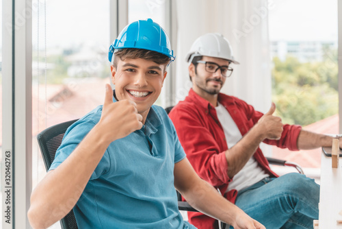 handsome cheerful engineer is having fun in front of the computer at work. happiness concept.