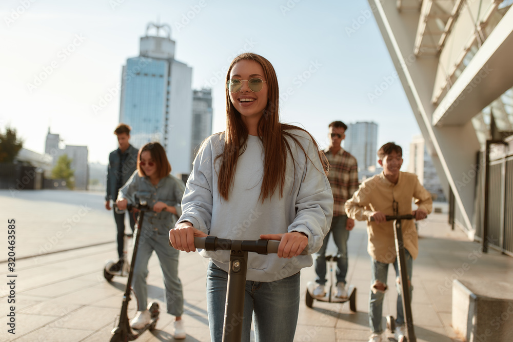 More smiles per hour. A group of friends riding kick scooters and segways on a sunny day More smiles per hour. A group of friends riding kick scooters and segways on a sunny day