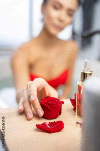 Young woman looking at a rose flower