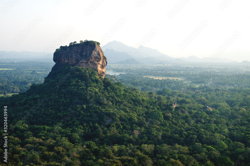 Lions Rock surrounded by forest and mountains in background in Sigiriya, Sri Lanka
