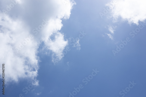 Blue sky background and white clouds passing by.