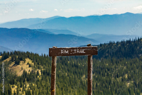 A wooden signboard on the top of the mountain hill. Rim trail sign in the Kootenay valley mountains, in Creston, British Columbia, Canada photo