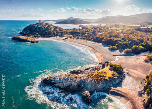 View from flying drone. Astonishing spring view of popular tourist destination - Acropoli di Bithia with Torre di Chia tower on background. Aerial morning view of Sardinia island, Italy, Europe. photo