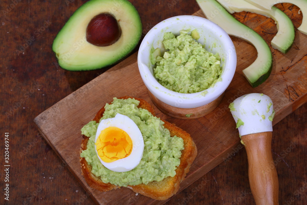 Sandwich with avocado and egg on a wooden table Sandwich with avocado and egg on a wooden table