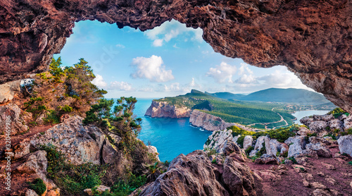 Fototapeta Naklejka Na Ścianę i Meble -  Unbelievable summer view of Caccia cape from the small cave in the cliff. Marvelous morning scene of Sardinia island, Italy, Europe. Aerial Mediterranean seascape. 