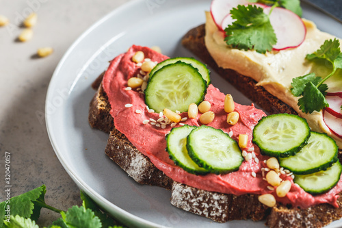 Beetroot and classic hummus toasts. Vegan food concept.