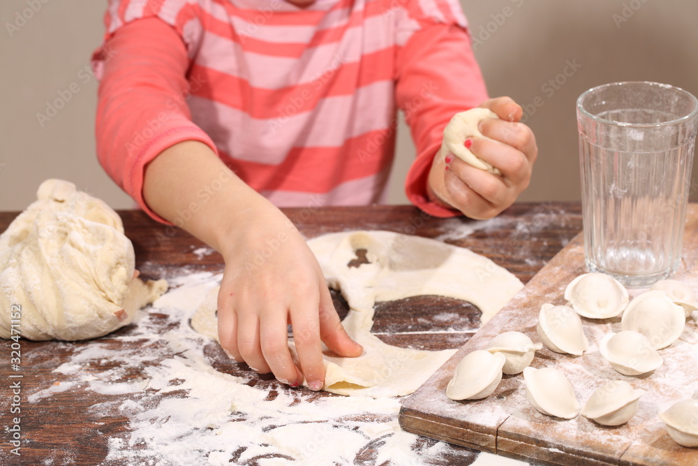 Baby sculpts dumplings in the kitchen