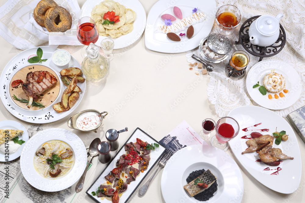 Served table in the restaurant. Mushroom soup, meat plate, steak with potatoes and tea with dessert Served table in the restaurant. Mushroom soup, meat plate, steak with potatoes and tea with dessert