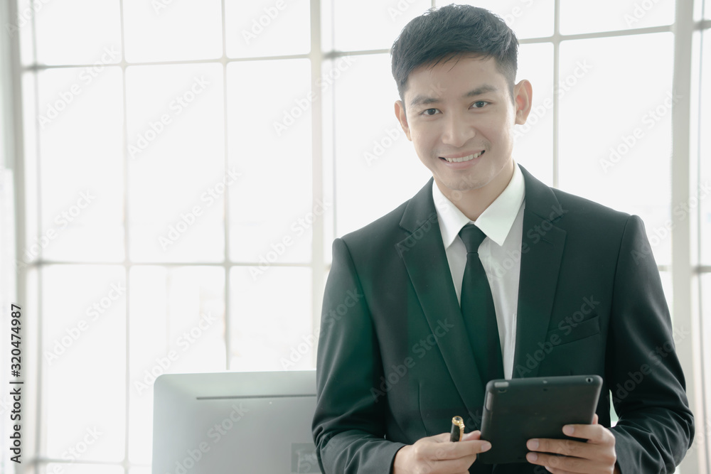 Portrait of a young businessman using a digital tablet in a modern office