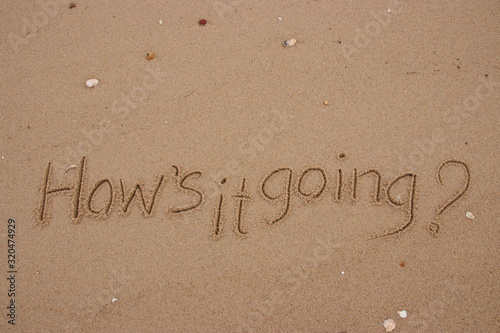 inscription on the sand, Handwriting words "How's it going?" on sand of beach.