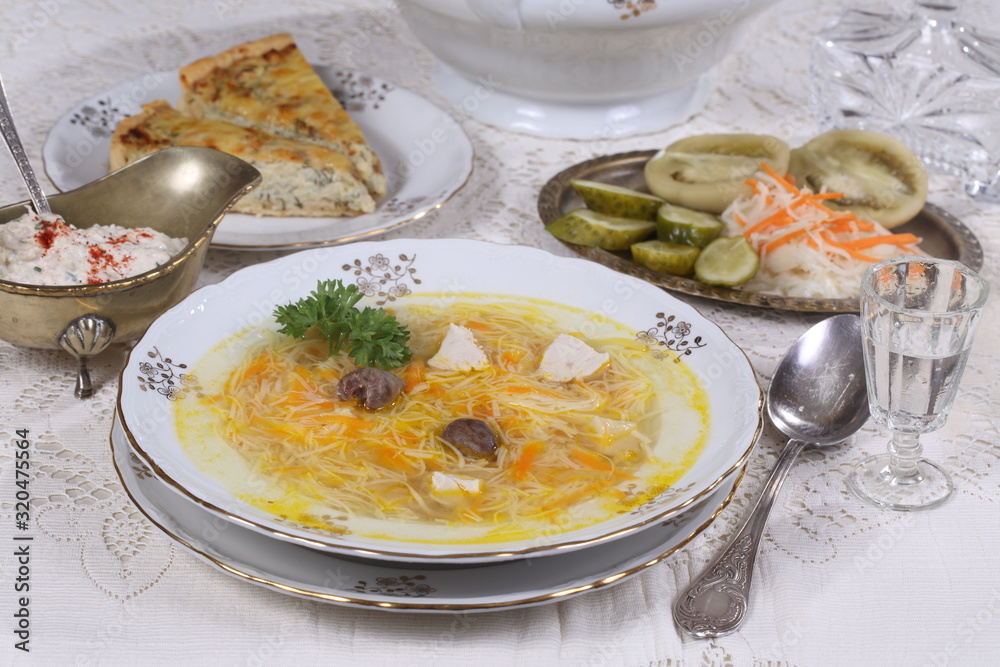 chicken soup with vermicelli, a glass of vodka and pickles