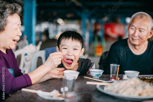 Grandmother feeding her grandson in restaurant