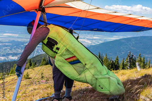 Man with hang-glider getting ready to fly and checking his gears and equipment. A Delta plane pilot about to launch. Medium shot