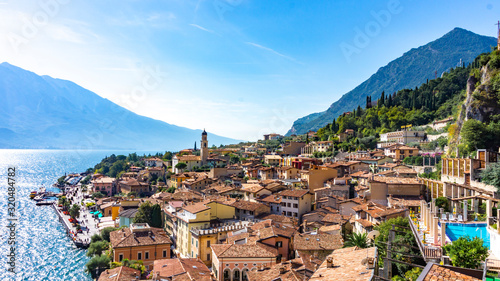 Postcard scenic panoramic view of the old European town on the shore of a mountain lake. City of Limone sul Garda aerial view. Tiled roofs of a medieval town in the Alps © nieriss