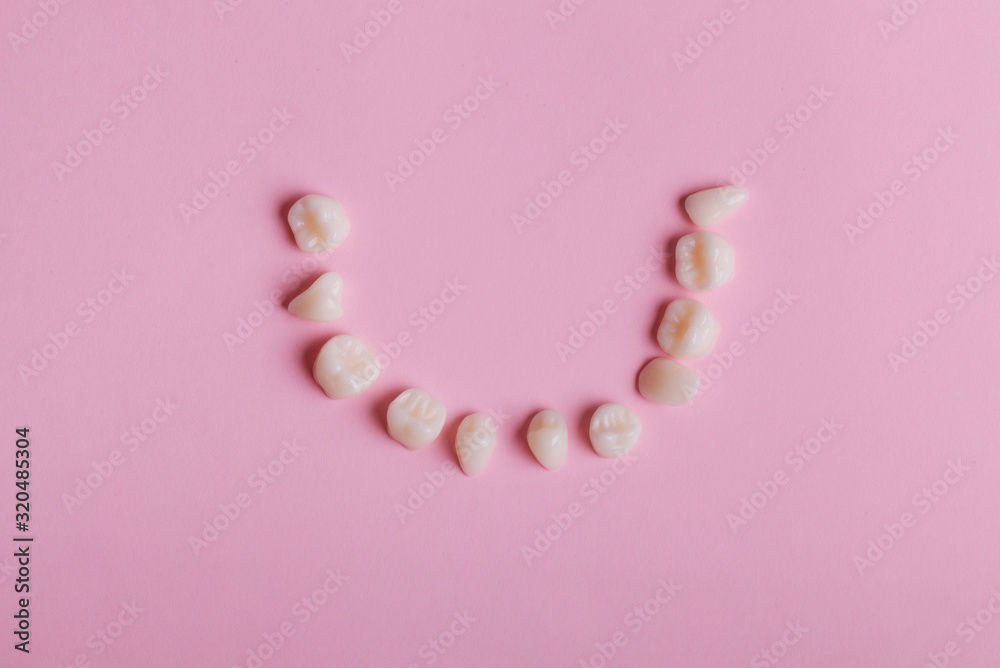 Dental tooth on pink background top view. Smiling concept
