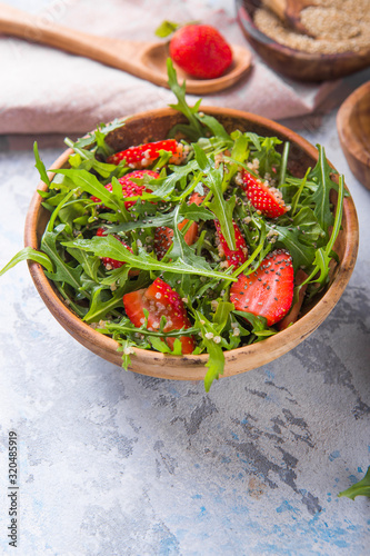 Diet menu concept. Summer Healthy salad with quinoa, strawberry, and arugula. Top view flat lay background on light stone table with copy space.