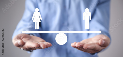 Man showing balance scale. Man and Woman equality photo