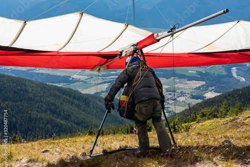 Paraglider about to launch at the top of the hill, Creston, British Columbia, Canada. Kootenay valley mountains in the background