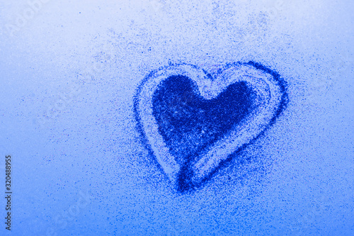 Blue heart symbol of love from sparkles blue background. Valentines day cosmetics concept. Horizontal frame copy space.