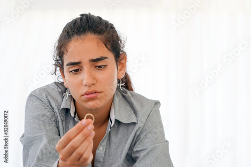 Portrait of woman holding wedding ring in hands, engaged girl doubts about marriage proposal, abandoned wife depressed after getting divorced. 