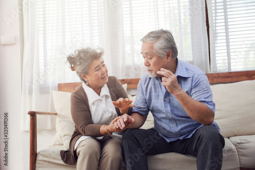 Retirement couples take care of each other when they are Alzheimer's Disease, sitting on the couch in the house. Ensuring mutual encouragement.