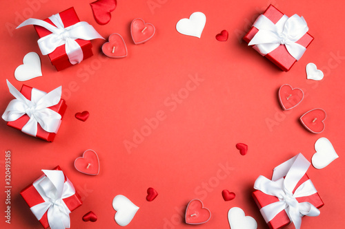Frame of gifts, hearts and candles on red background. Valentine's day concept.