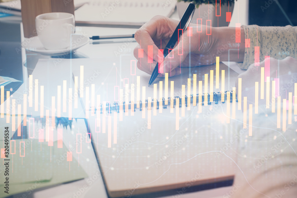 Hand taking notes in notepad. Forex chart holograms in front. Concept of research. Double exposure Hand taking notes in notepad. Forex chart holograms in front. Concept of research. Double exposure