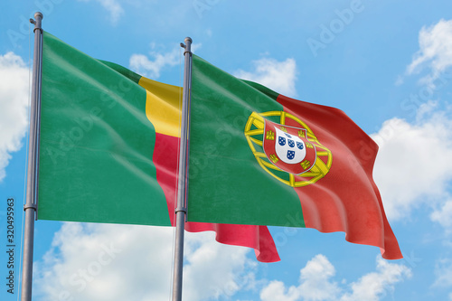 Portugal and Benin flags waving in the wind against white cloudy blue sky together. Diplomacy concept  international relations.