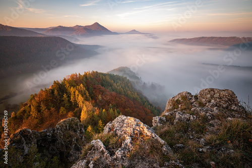 Fog in the valley between the mountains, sun hitting the rocks and colorful leaves on trees, Slovakia © Peter Binó