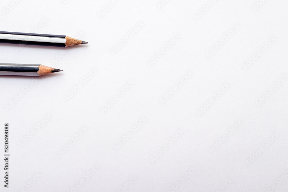 Pencils and eraser on white paper background. Copy space_ Pencils and eraser on white paper background. Copy space_
