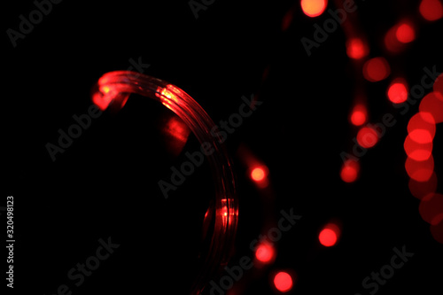 Christmas garland bright red light blur bokeh. Street and home decorations from light bulbs defocus for a holiday.