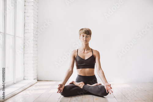Young beautiful woman practicing yoga in yoga studio. Young beautiful girl doing exercises at home. Harmony, balance, meditation, self-care, relaxation, healthy lifestyle, mindfulness concept