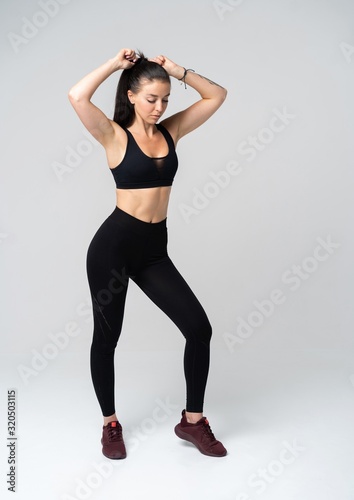 Young fit woman in sports outfit, studio photo.