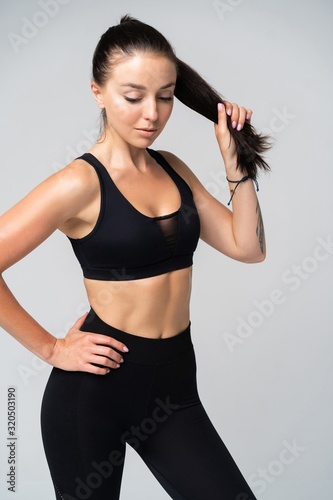 Attractive young adult in sportswear posing on white background.