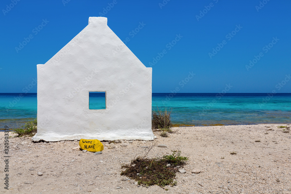 One white slave house on beach near blue sea