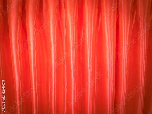 The light and shadow of the curtains on vintage theatre. Glossy red curtain background.