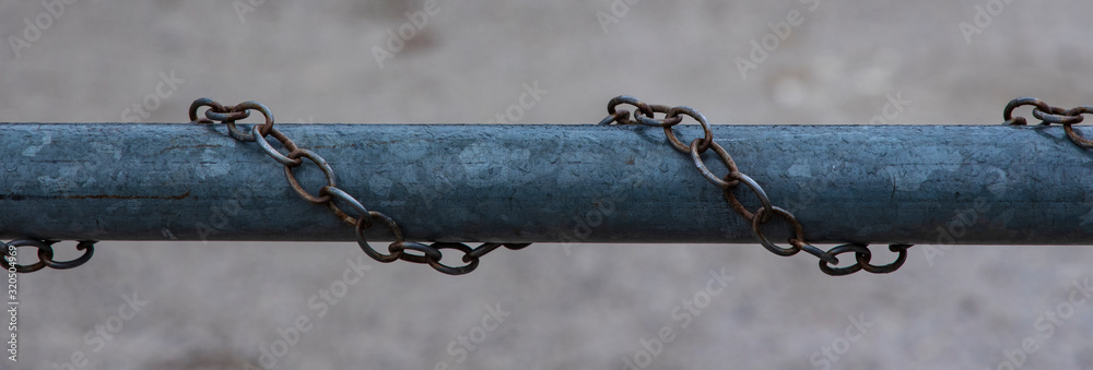 Obraz premium iron pipe rusty chains around horizon picture concept of fenced industry area with blurred background space