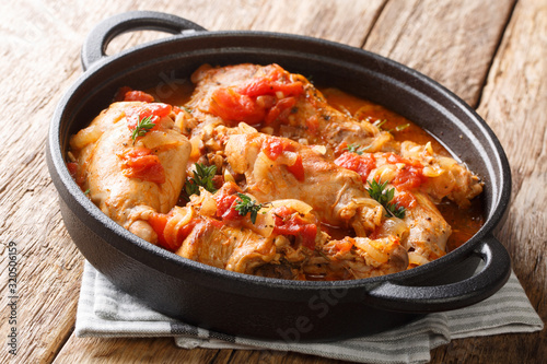 Andorra recipe stew of rabbit in tomato sauce with white wine and herbs close-up in a pan. horizontal