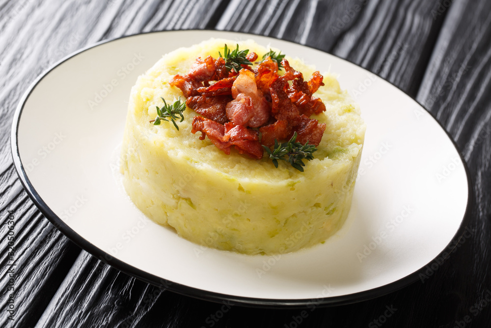 Tasty Trinxat mashed potatoes and green cabbage with fried bacon closeup in a plate. horizontal Tasty Trinxat mashed potatoes and green cabbage with fried bacon closeup in a plate. horizontal