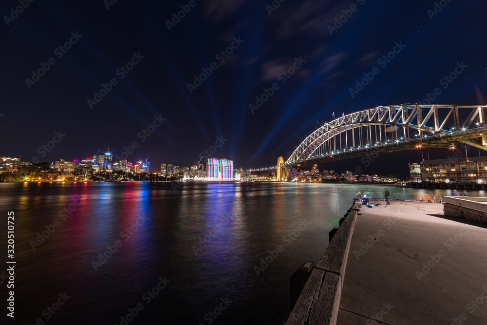 Modern futuristic cityscape with bridge and lights at night